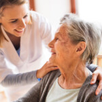Health visitor and a senior woman during home visit. A nurse talking to an elderly woman.